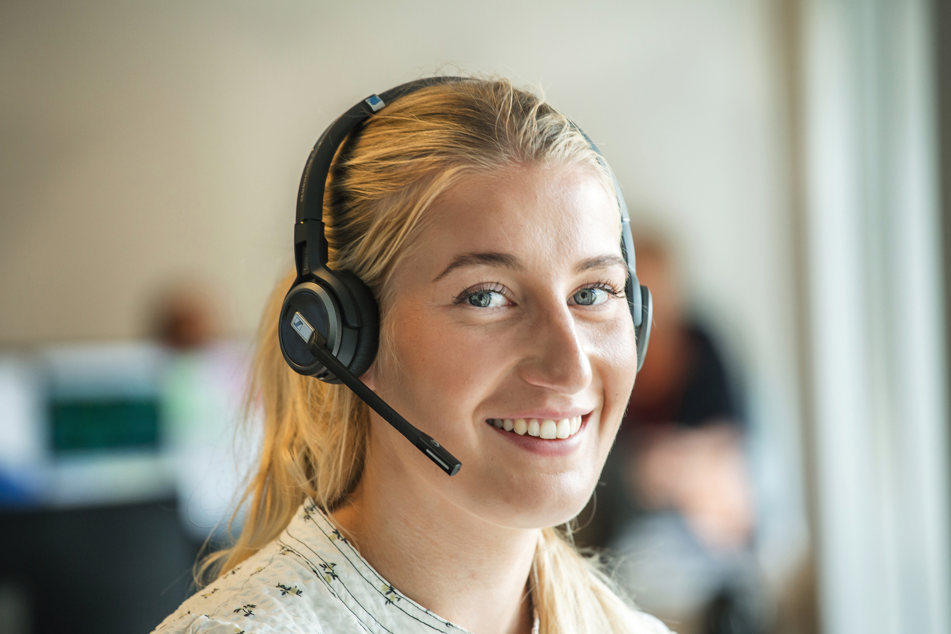 Lyshåret kvinde med headset smiler