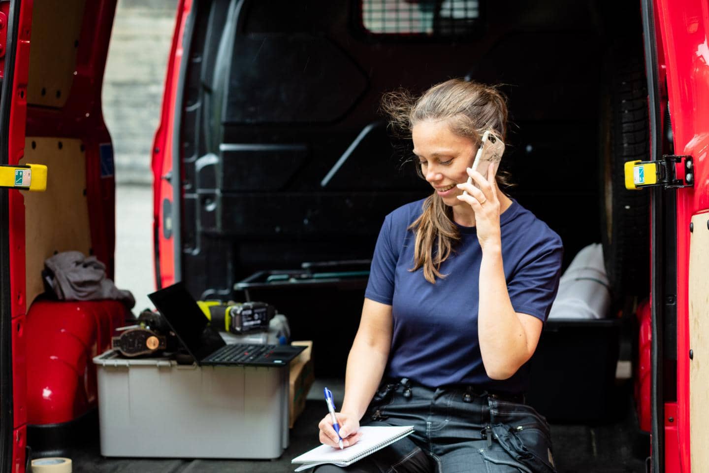 Kvinde taler med kunde i sin varebil