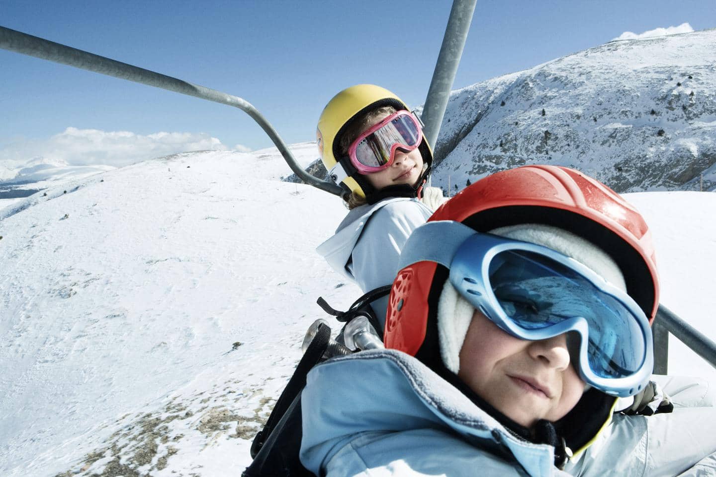 Kom godt på skiferie - børn i skilift med snelandskab i baggrund